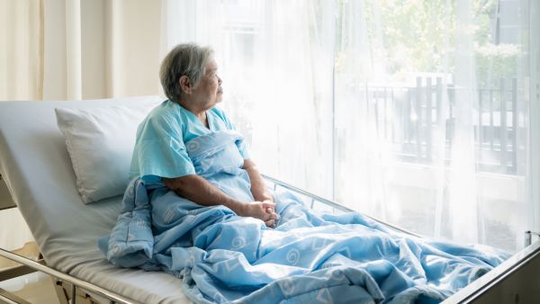 Idosa tranquila em cama após ser tratada em ambiente hospitalar
