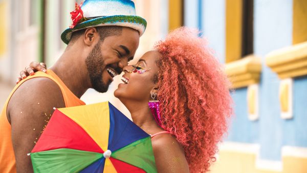 Casal feliz curtindo carnaval já conscientizados sobre importancia de uso de camisinha em relações sexuais