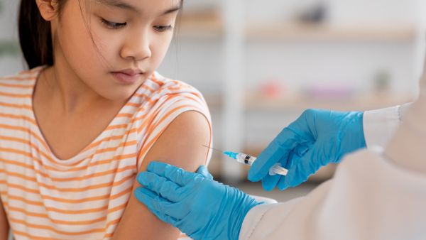 Criança tomando vacina representando nova indicação da Anvisa para imunização contra HPV