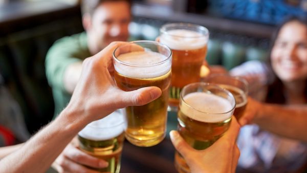 Pessoas bebendo bebida alcoólica com tranquilidade em estabelecimento no carnaval após seguir orientações para evitar intoxicação metanol em bebidas