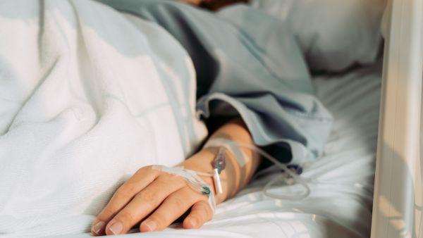 Mulher deitada em cama de hospital após bateria de exames em mutirão para mulheres