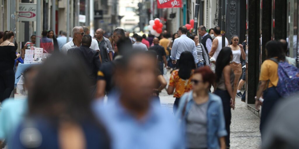 Diversas pessoas andando em rua fazendo alusão ao aumento de mortes por câncer colorretal entre a população