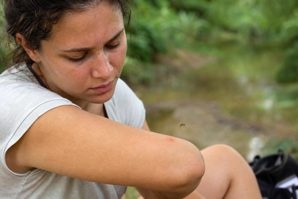 Imagem ilustrativa gerada por IA mostrando uma pessoa sendo picada por mosquito e representando por que algumas pessoas atraem mosquitos com maior frequência.