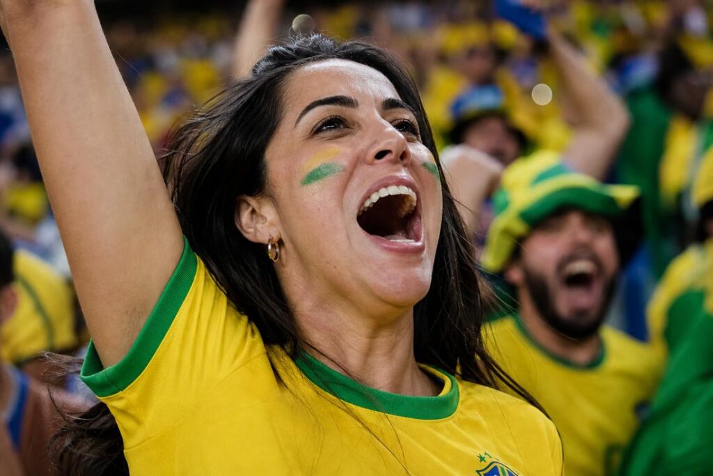 Imagem ilustrativa gerada por IA mostrando uma torcedora comemorando um gol durante uma partida de futebol, relacionada aos cuidados sobre como recuperar a voz.