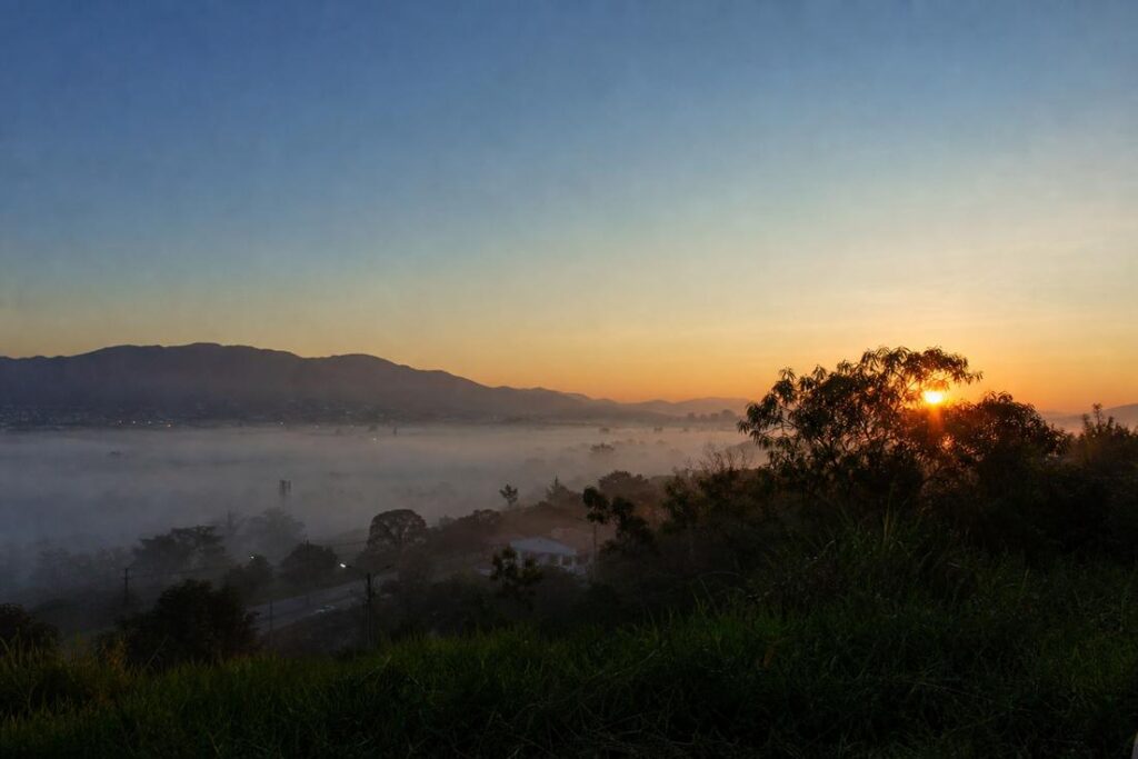 Imagem ilustrativa gerada por IA representando a previsão do tempo no Vale do Aço com nevoeiro durante a manhã e céu ensolarado ao longo da tarde.