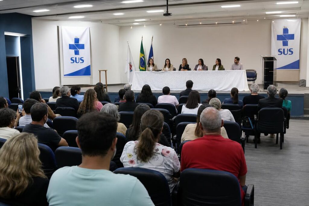 Auditório com pessoas participando de plenária de saúde em Coronel Fabriciano para discutir políticas do SUS