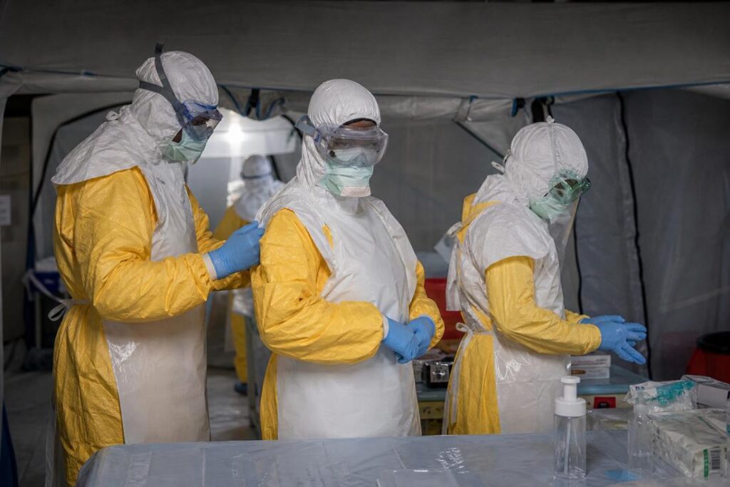 Profissionais de saúde utilizando equipamentos de proteção durante atendimento relacionado ao primeiro caso de Ebola na França.