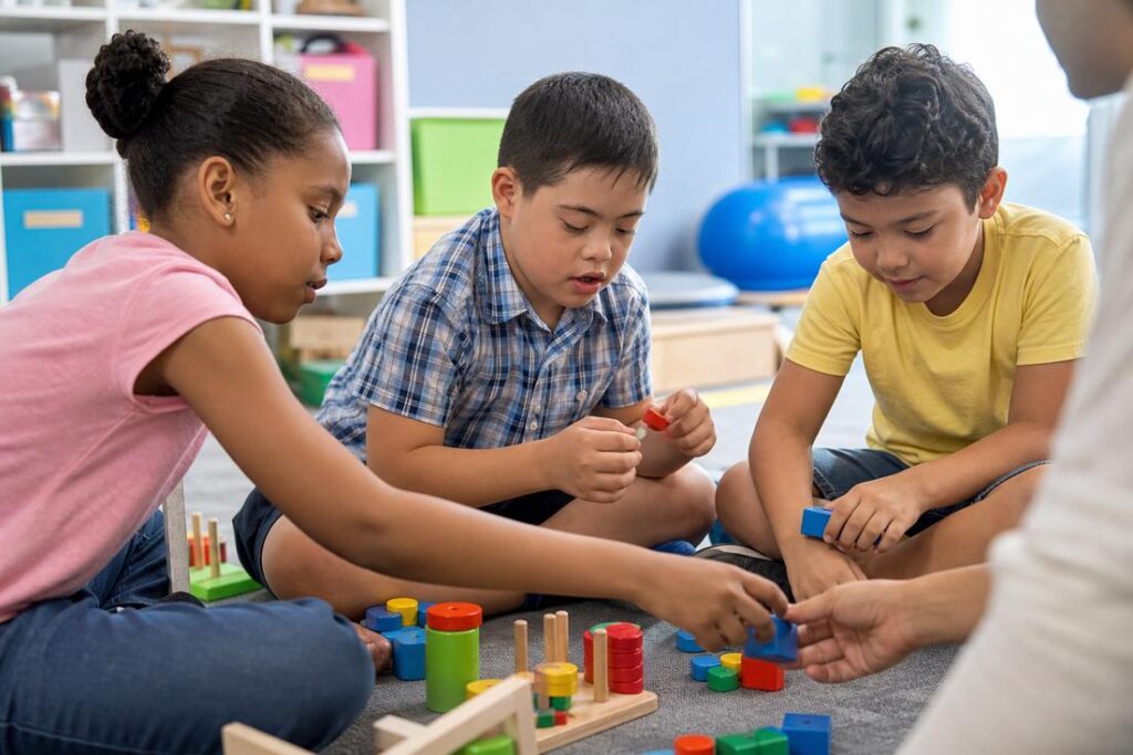 Criança autista em sala de aula com apoio de professora praticando educação inclusiva