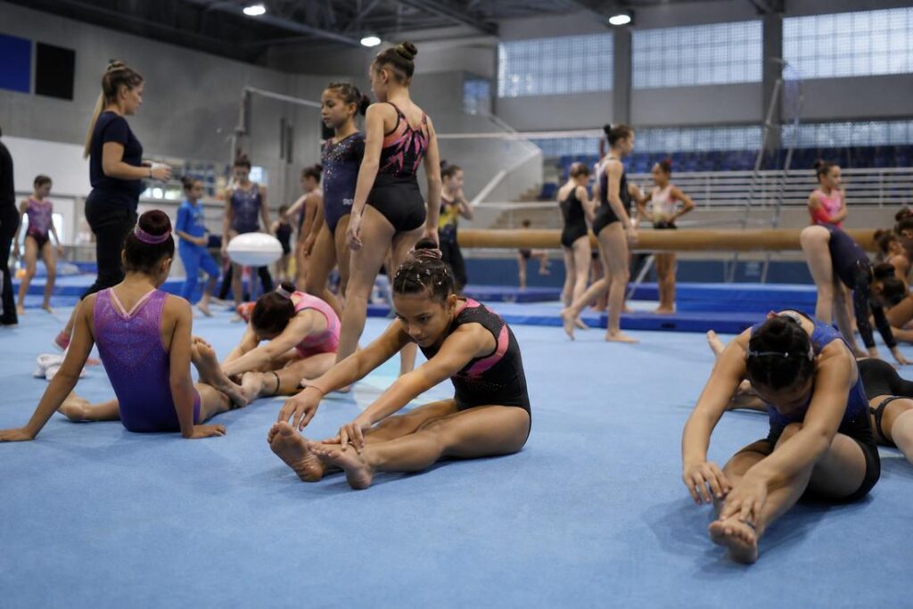 Atletas de ginástica artística competindo no Integra Gym em Timóteo com presença de público