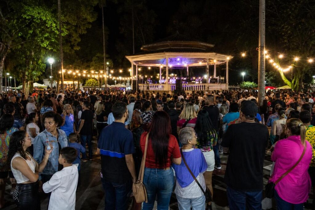 Festival de música ao ar livre na Praça do Coreto em Timóteo com famílias assistindo apresentação