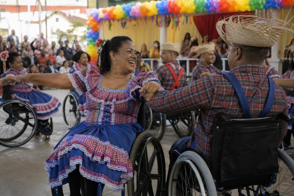 Dançarinos em cadeira de rodas durante apresentação do Arraiá Acessível em Belo Horizonte